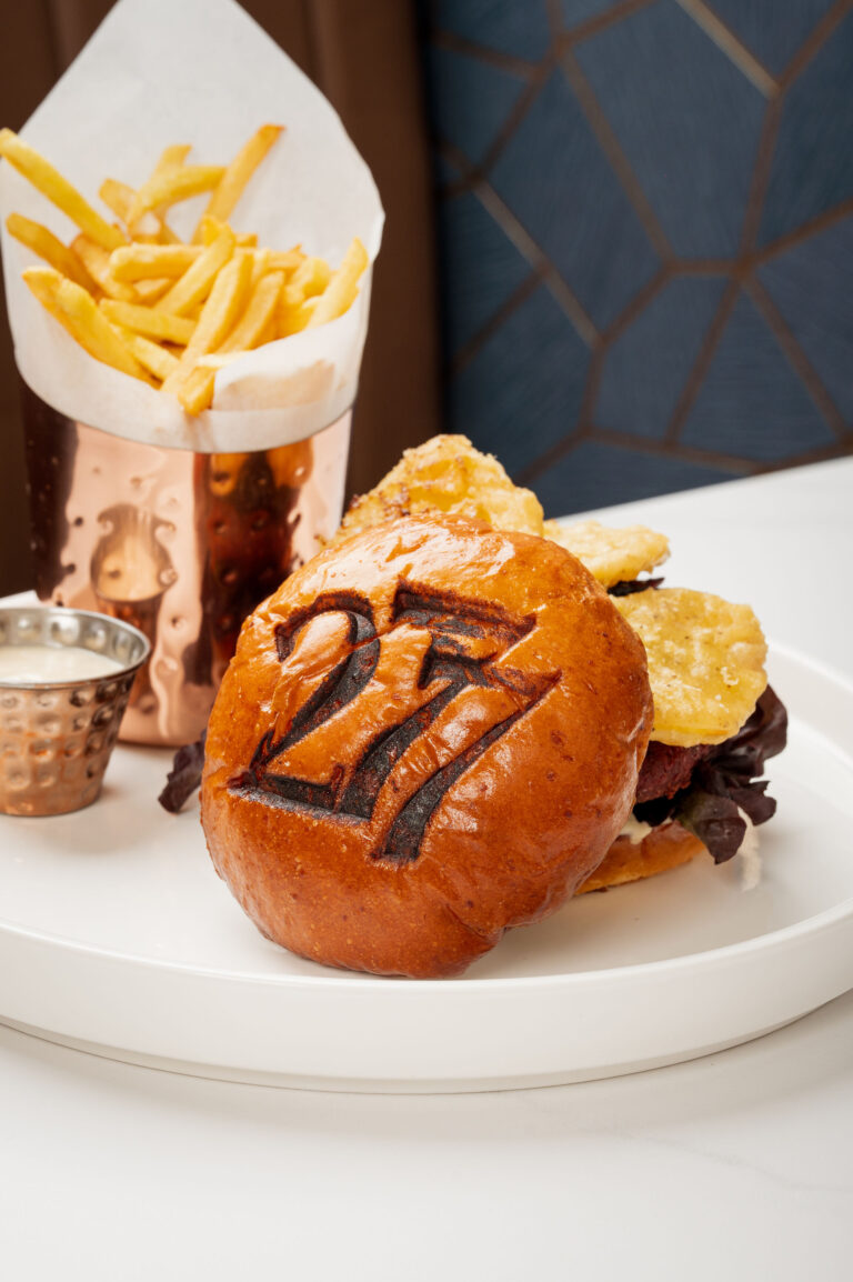 Gourmet Lentil Patty Burger served on a branded 277 brioche bun with roasted garlic aioli and in-house pickles, accompanied by crispy French fries in a copper cup